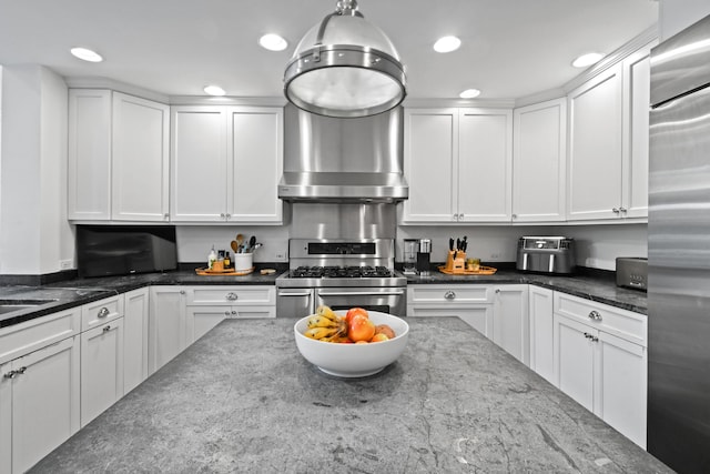 kitchen featuring dark stone counters, white cabinets, and stainless steel appliances