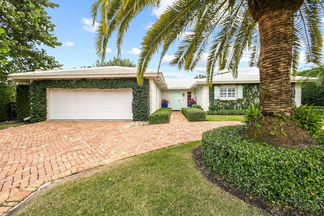 single story home with an attached garage and decorative driveway