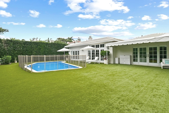 rear view of house featuring a fenced in pool, french doors, a yard, and fence