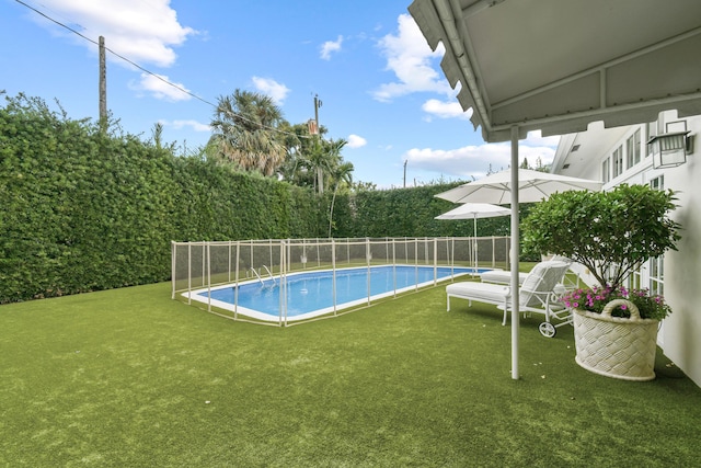 view of swimming pool featuring a yard, a fenced in pool, and a fenced backyard