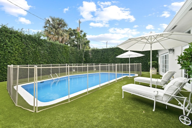 view of swimming pool with a lawn, french doors, a fenced backyard, and a fenced in pool