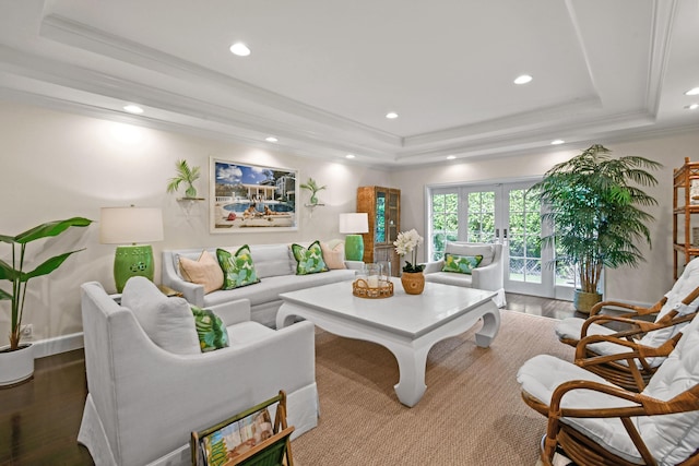 living room featuring ornamental molding, french doors, a tray ceiling, and wood finished floors