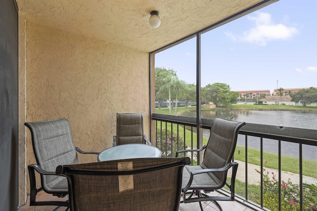 sunroom / solarium featuring a water view