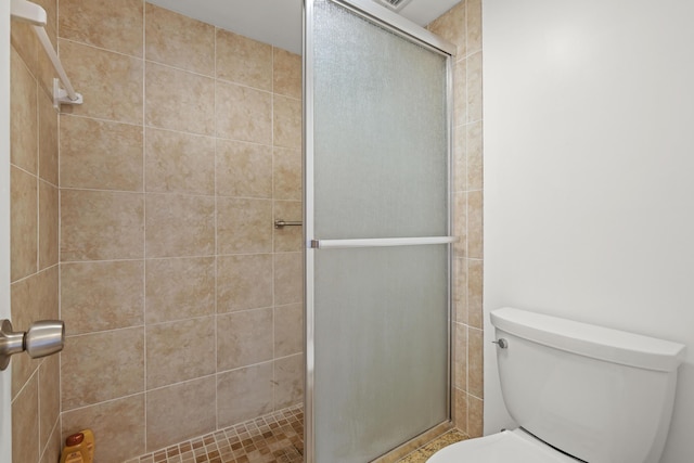 full bath featuring a stall shower and toilet