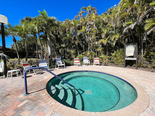 view of swimming pool with a patio area and a hot tub