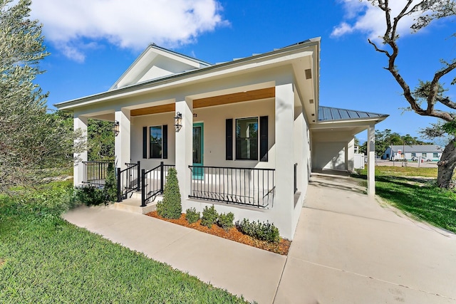 view of front of home with covered porch, metal roof, a standing seam roof, and stucco siding