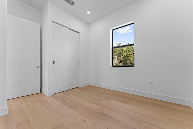 unfurnished bedroom featuring baseboards, visible vents, light wood-style floors, a closet, and recessed lighting