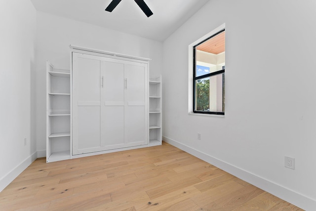 unfurnished bedroom with light wood-style flooring, baseboards, and a ceiling fan