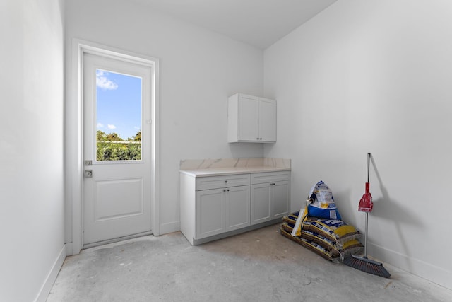 doorway featuring concrete floors and baseboards