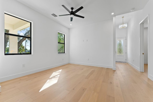 empty room featuring light wood-type flooring, visible vents, plenty of natural light, and baseboards