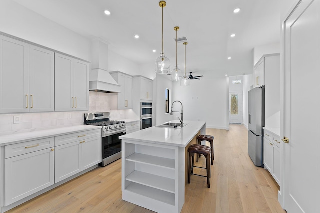 kitchen featuring custom exhaust hood, open shelves, tasteful backsplash, appliances with stainless steel finishes, and a sink