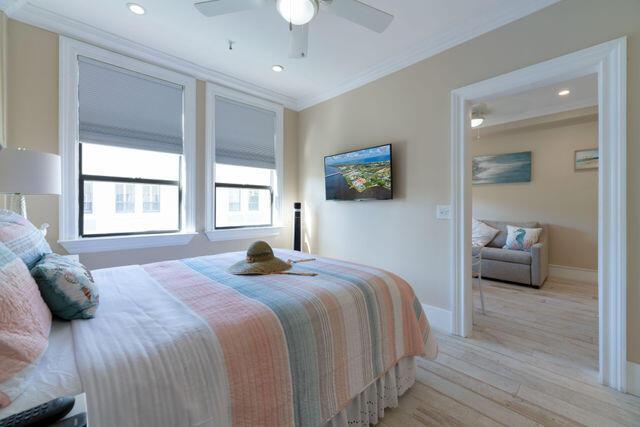 bedroom with baseboards, light wood-style flooring, ceiling fan, crown molding, and recessed lighting