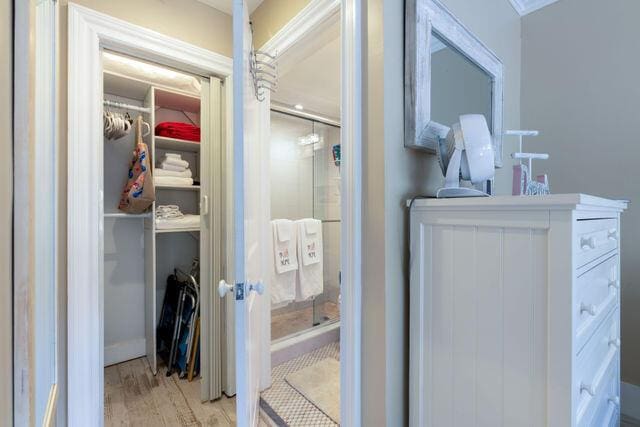 bathroom with a spacious closet and wood finished floors