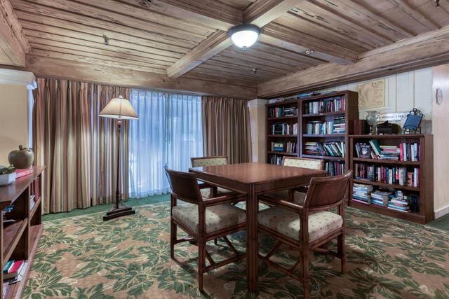 carpeted dining area featuring wooden ceiling and beamed ceiling