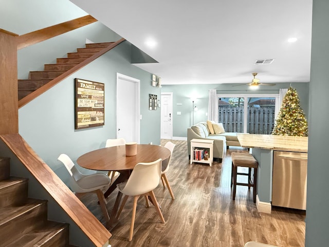 dining room featuring stairway, a ceiling fan, wood finished floors, visible vents, and baseboards