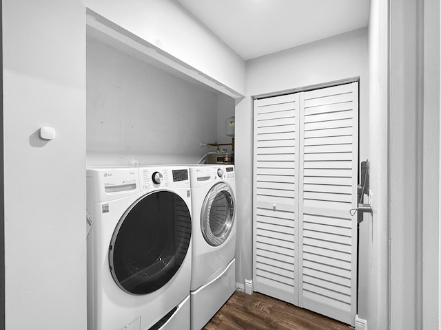 washroom featuring washer and dryer, laundry area, and dark wood finished floors