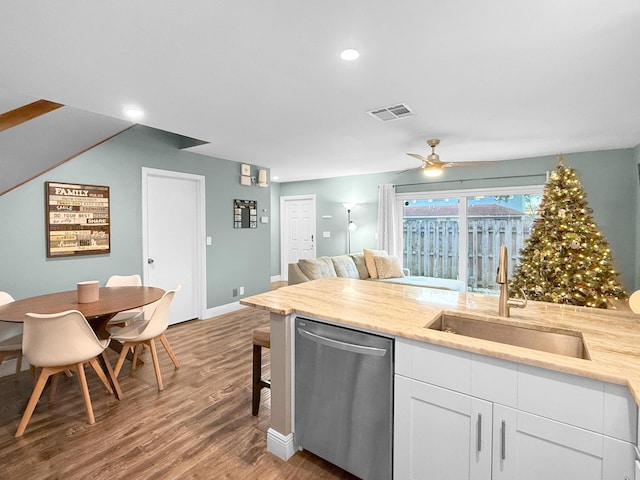 kitchen with visible vents, dishwasher, wood finished floors, white cabinetry, and a sink