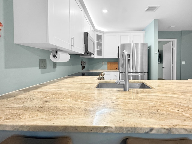 kitchen featuring visible vents, glass insert cabinets, light countertops, appliances with stainless steel finishes, and white cabinets