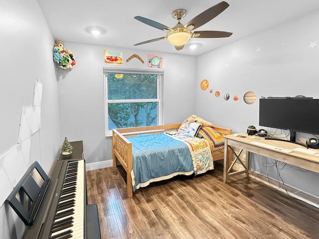 bedroom with a ceiling fan, wood finished floors, and baseboards