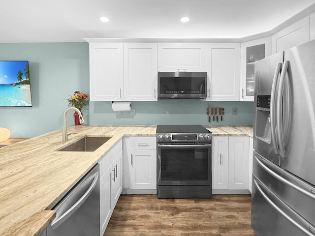 kitchen with light stone counters, stainless steel appliances, dark wood-type flooring, and a sink