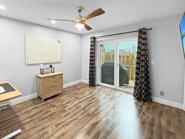 spare room with baseboards, wood finished floors, and a ceiling fan