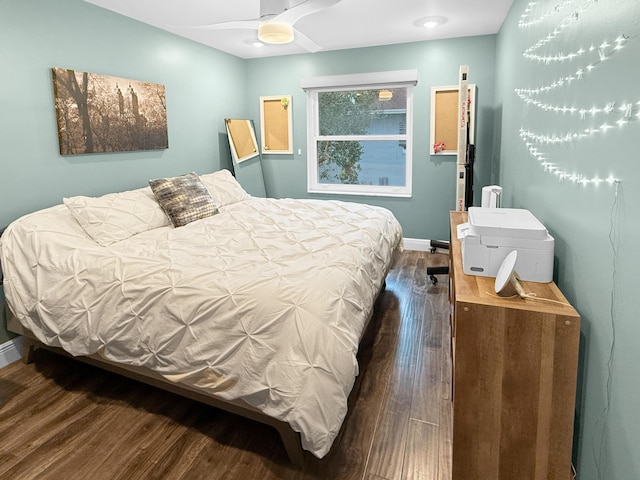 bedroom featuring dark wood finished floors, a ceiling fan, and baseboards