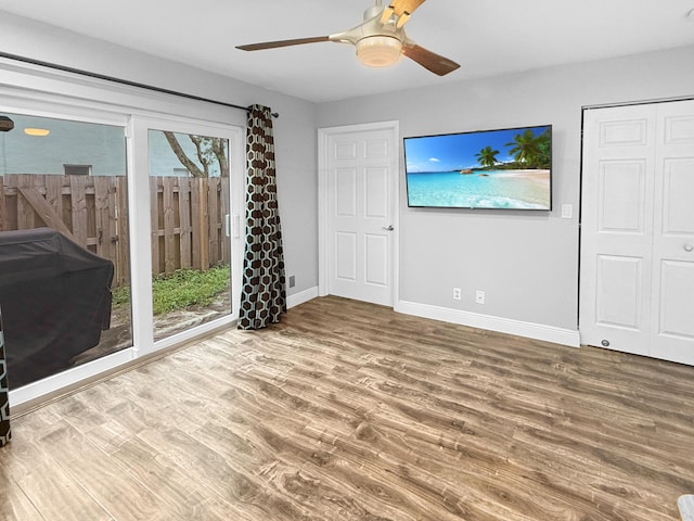 unfurnished bedroom featuring a ceiling fan, baseboards, and wood finished floors