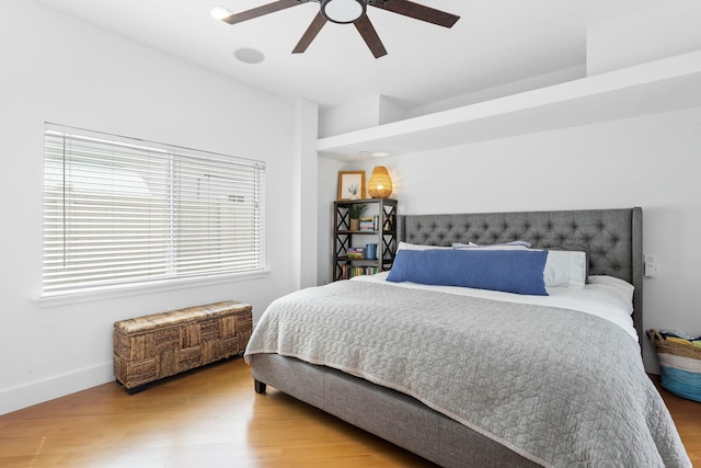 bedroom featuring ceiling fan, wood finished floors, and baseboards