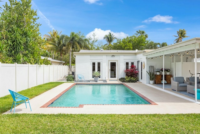 back of property with a lawn, a patio area, a fenced backyard, and a fenced in pool