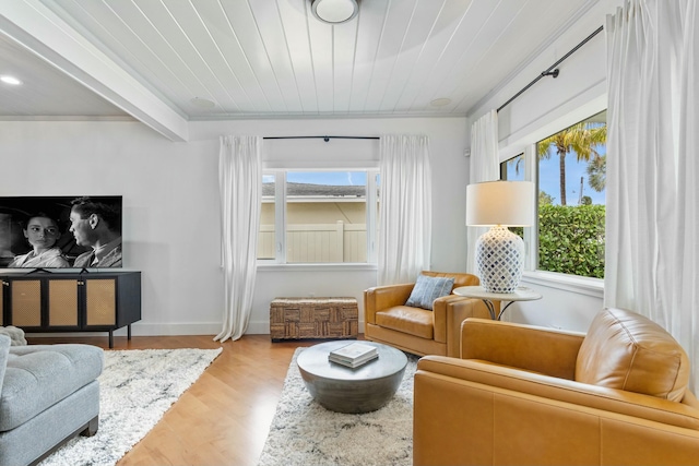 sitting room with wood ceiling, beamed ceiling, a wealth of natural light, and light wood-style floors