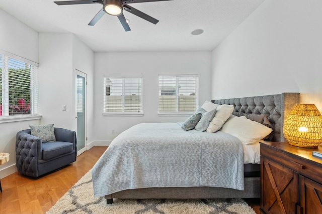 bedroom with ceiling fan, light wood finished floors, and baseboards