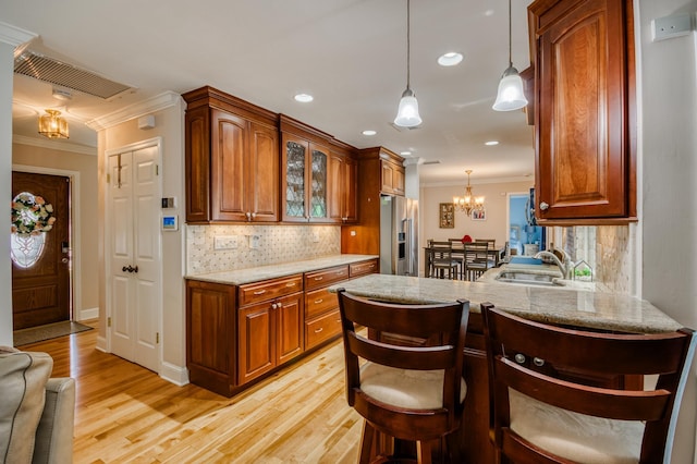 kitchen with a sink, tasteful backsplash, ornamental molding, and high end fridge