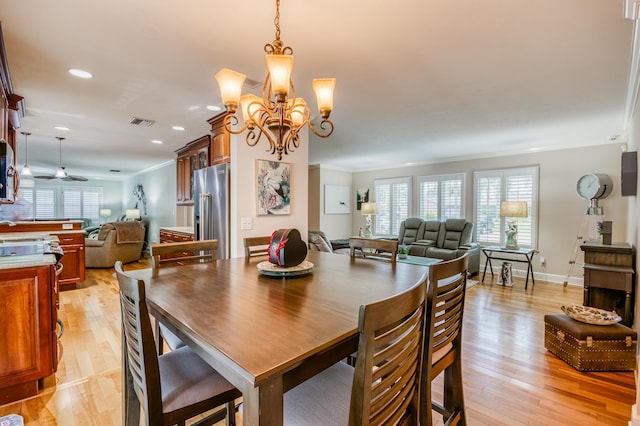 dining space with plenty of natural light, light wood-style flooring, visible vents, and crown molding