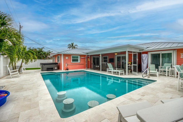 view of swimming pool featuring a hot tub, a patio area, a fenced backyard, and a fenced in pool