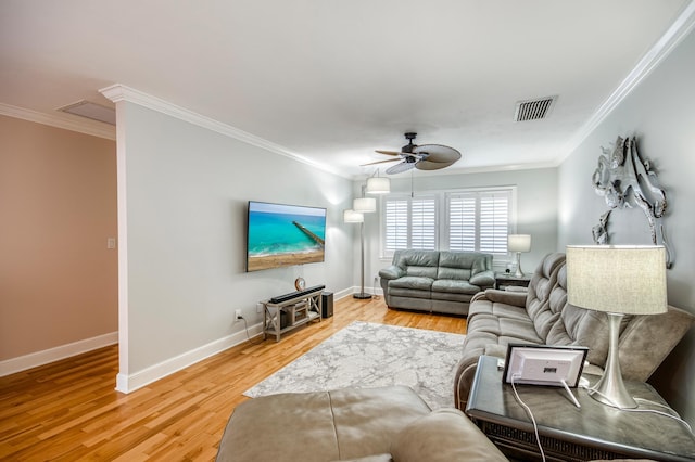 living room featuring light wood-type flooring, ceiling fan, visible vents, and crown molding