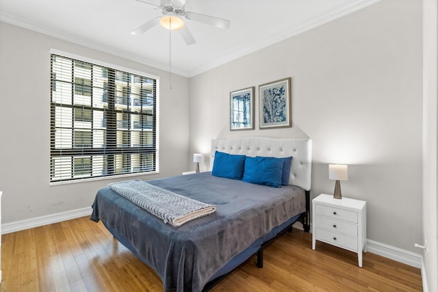 bedroom featuring ceiling fan, crown molding, baseboards, and wood finished floors