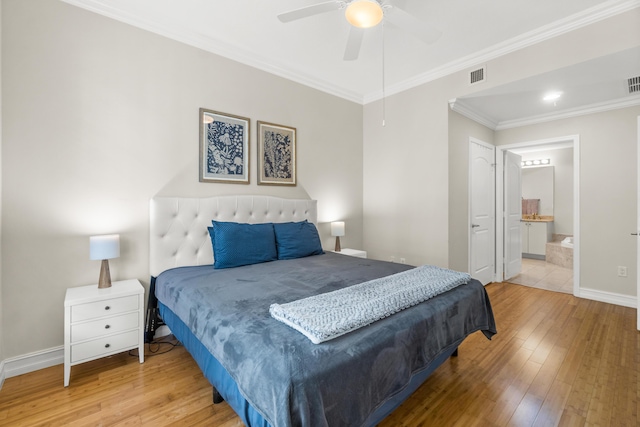 bedroom with hardwood / wood-style flooring, baseboards, visible vents, and crown molding