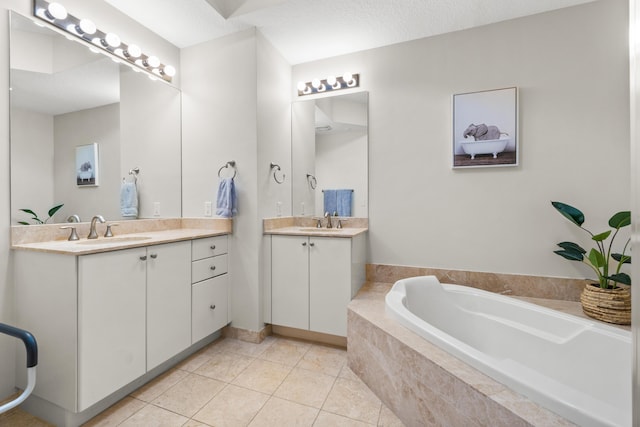 full bathroom featuring a garden tub, two vanities, a sink, and tile patterned floors