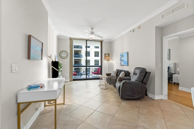 living room featuring light tile patterned floors, visible vents, baseboards, ornamental molding, and a wall of windows