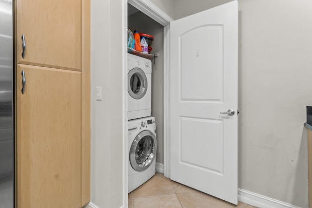 laundry area featuring light tile patterned floors, laundry area, and stacked washer and clothes dryer