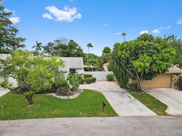 view of front of property featuring a front lawn, fence, and a garage