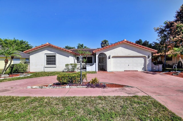 mediterranean / spanish home featuring a garage, driveway, a tile roof, and stucco siding