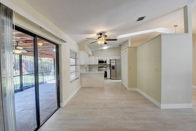 kitchen with visible vents, lofted ceiling, ceiling fan, appliances with stainless steel finishes, and white cabinetry