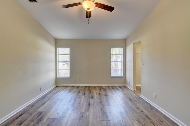 empty room featuring plenty of natural light, baseboards, and wood finished floors