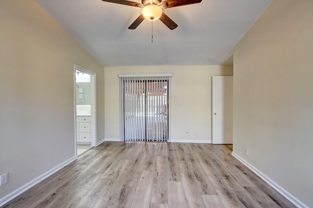 unfurnished room featuring lofted ceiling, light wood finished floors, and baseboards