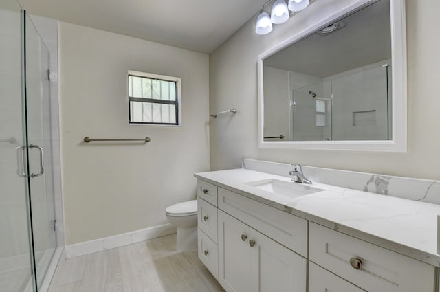 full bathroom featuring toilet, a shower stall, baseboards, and vanity