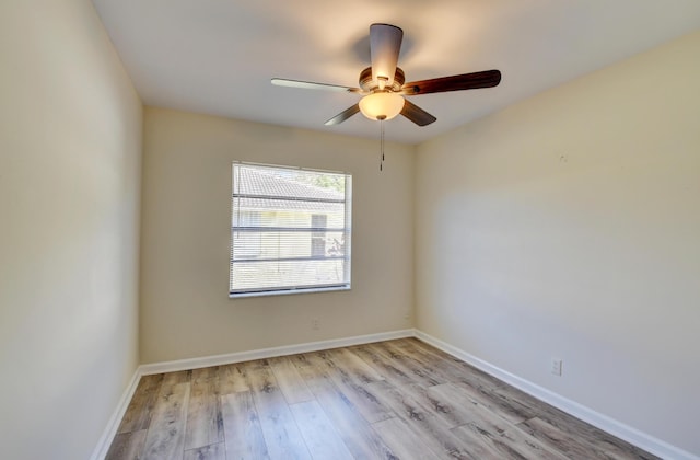 empty room with a ceiling fan, baseboards, and wood finished floors