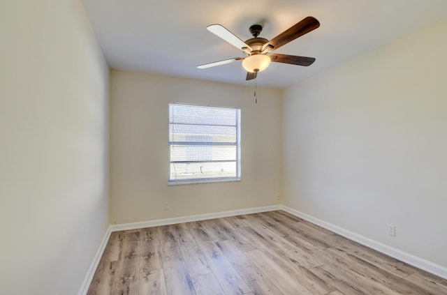 empty room with light wood finished floors, a ceiling fan, and baseboards