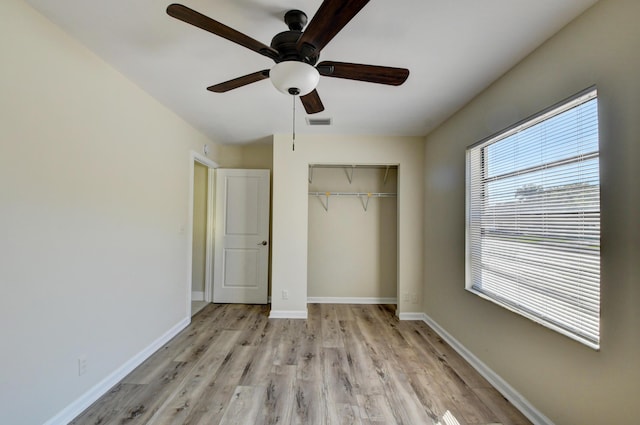 unfurnished bedroom with ceiling fan, visible vents, light wood-style floors, baseboards, and a closet