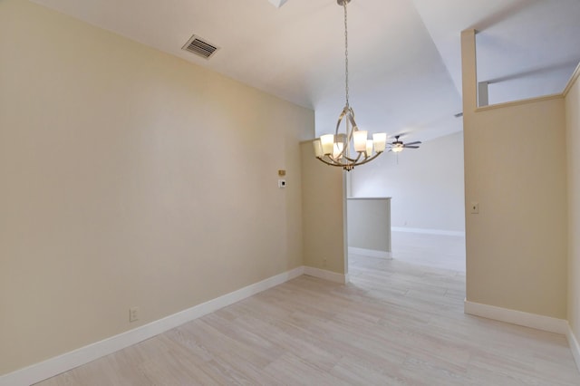 empty room featuring visible vents, light wood finished floors, baseboards, and ceiling fan with notable chandelier